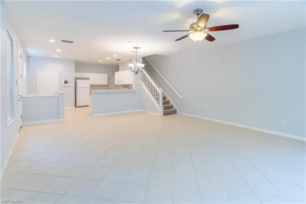 a view of an empty room with kitchen and kitchen view