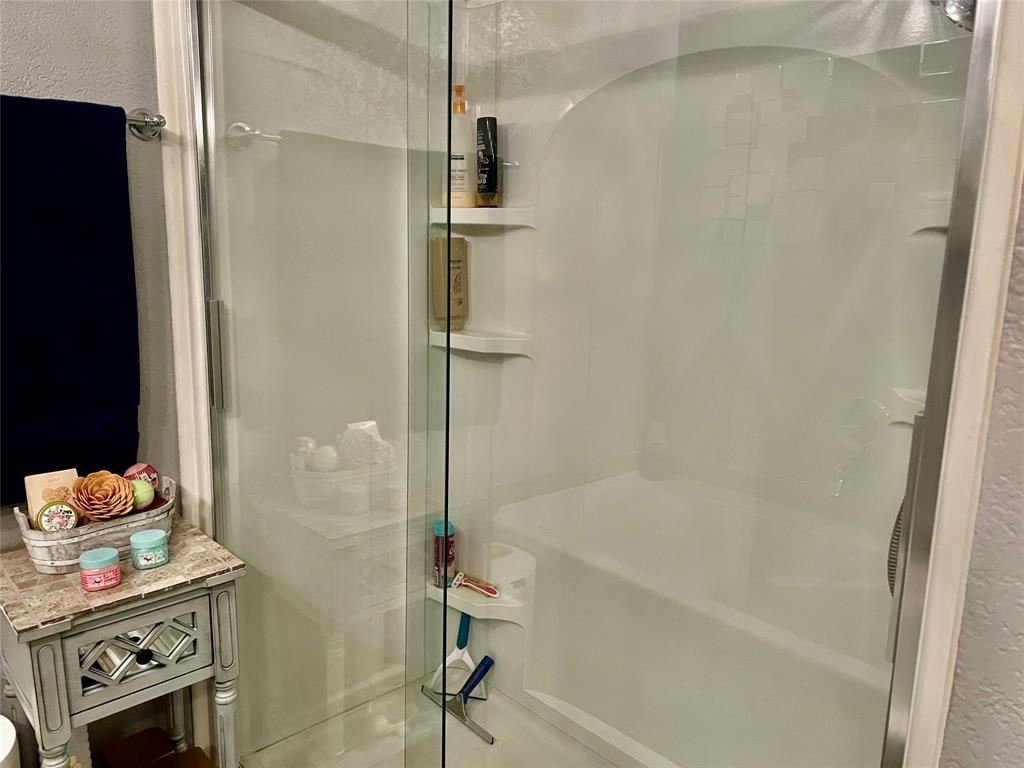 309 Broken Arrow Comanche, TX 76442 - Photo 29 of 35 a bathroom with a bathtub and a shower