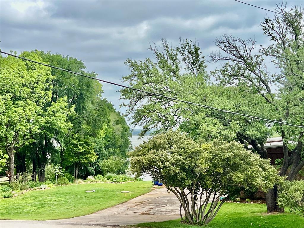 309 Broken Arrow Comanche, TX 76442 - Photo 3 of 35 a backyard of a house with lots of green space and garden