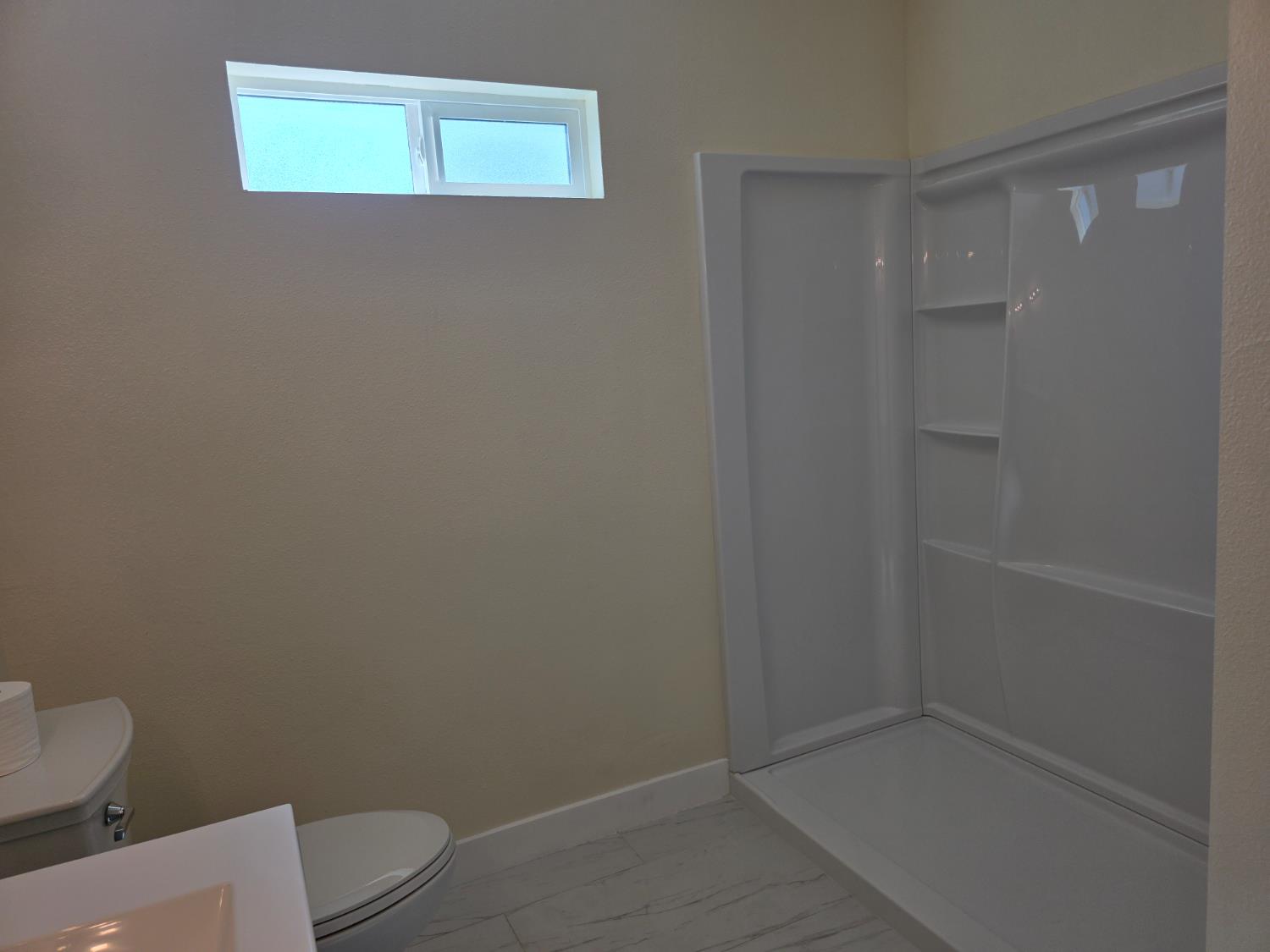 1098 East 21st Street Merced, CA 95340 - Photo 15 of 23 a bathroom with a toilet and a shower