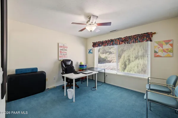 a view of a workspace with furniture and a window