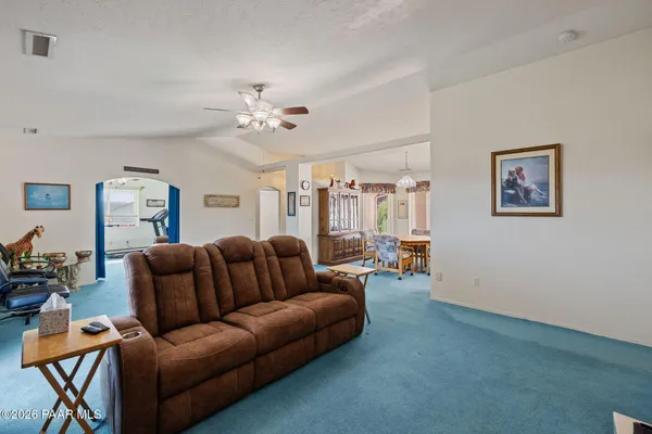 a living room with furniture a ceiling fan and a window