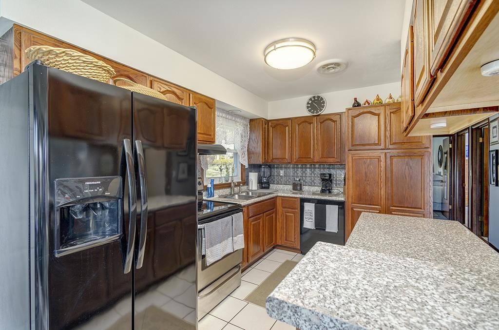 886 Breckenboro Road Davis, IL 61019 - Photo 16 of 37 a kitchen with stainless steel appliances granite countertop a refrigerator a stove and a sink with wooden floor
