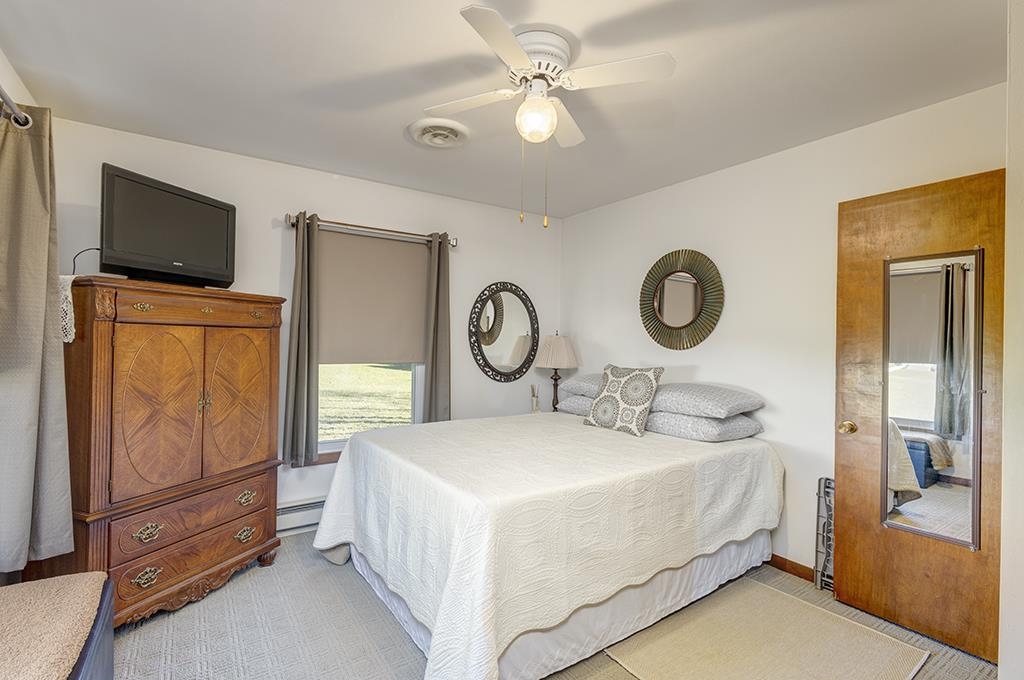 886 Breckenboro Road Davis, IL 61019 - Photo 24 of 37 a bedroom with a bed a mirror on the dresser and a chandelier
