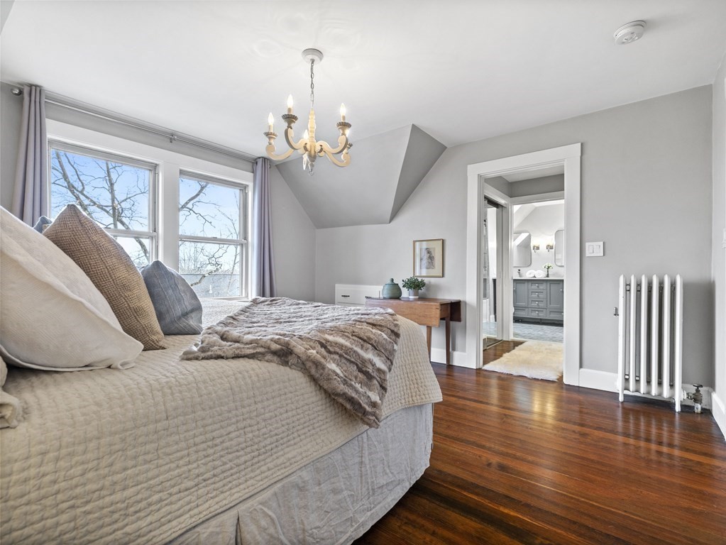 97 Crest Road Wellesley, MA 02482 - Photo 13 of 26 a bedroom with a bed chandelier and wooden floor