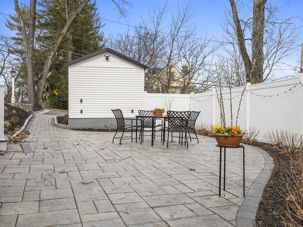 97 Crest Road Wellesley, MA 02482 - Photo 20 of 26 a view of a patio with table and chairs potted plants and a large tree