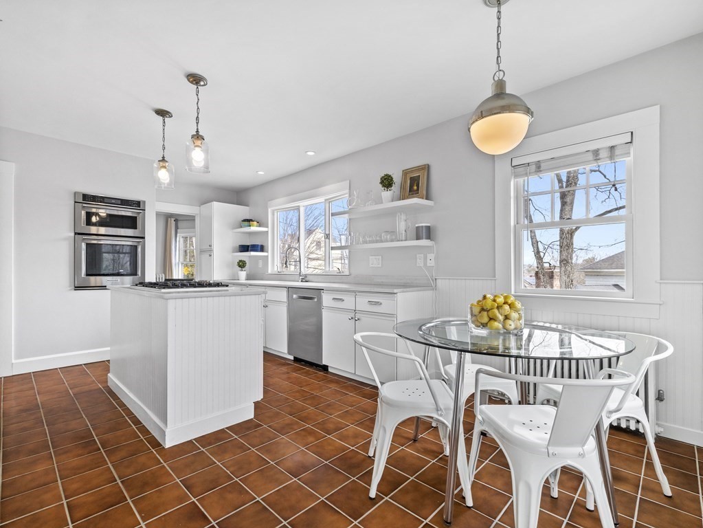97 Crest Road Wellesley, MA 02482 - Photo 6 of 26 a kitchen with stainless steel appliances granite countertop a sink a stove a dining table and chairs with wooden floor