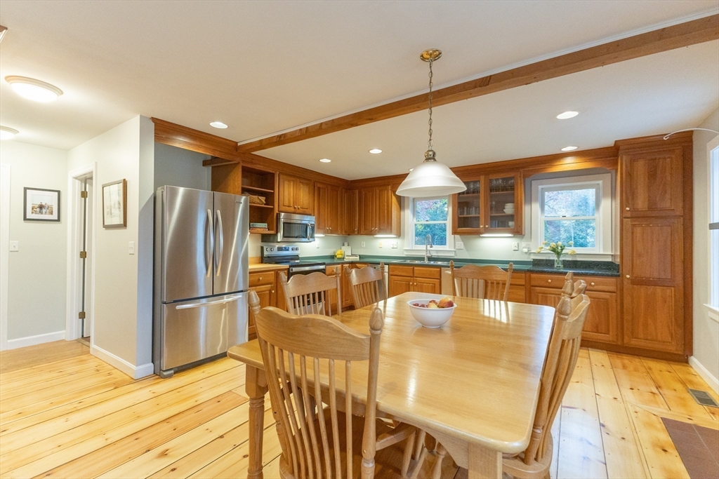 5 Old Wood Road North Attleboro, MA 02760 - Photo 8 of 41 a kitchen with stainless steel appliances granite countertop a refrigerator a stove top oven and a dining table with painted walls