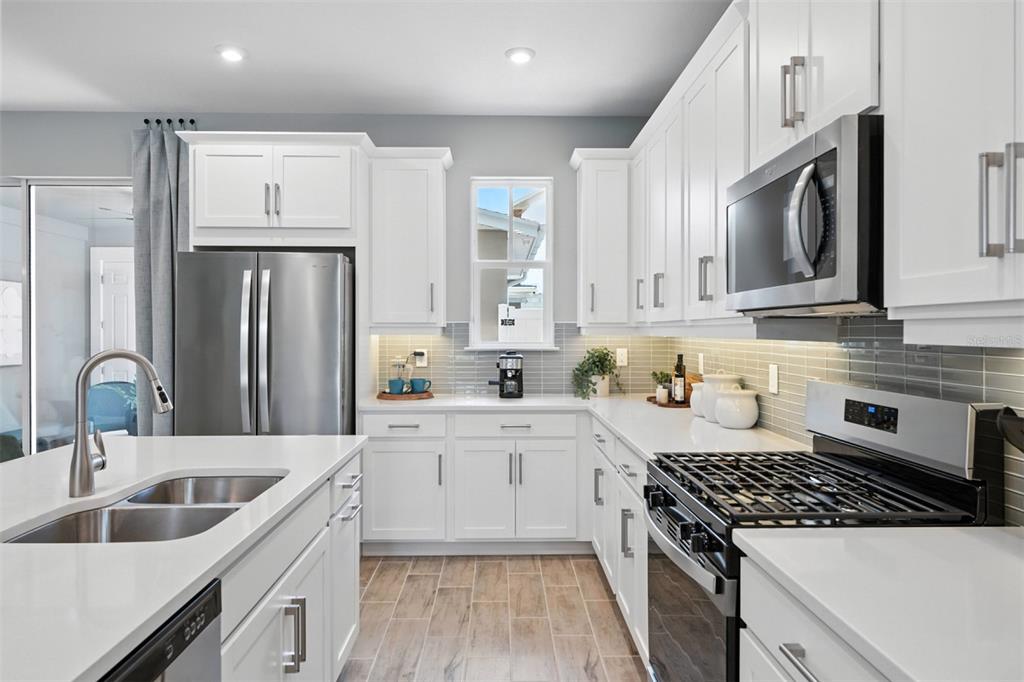 1792 Headland Loop Celebration, FL 34747 - Photo 5 of 31 a kitchen with refrigerator cabinets and a sink