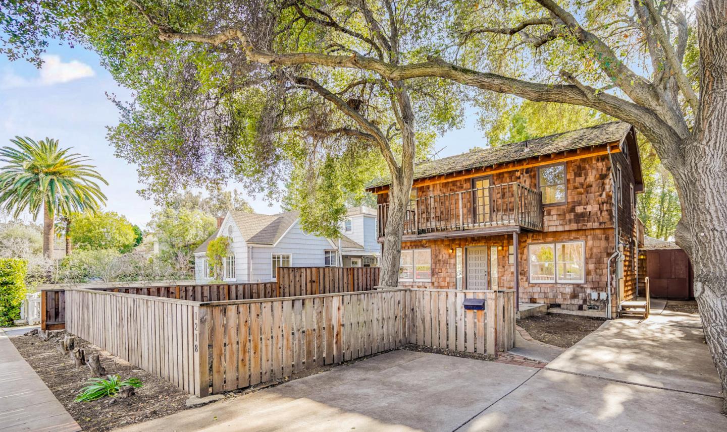 a view of a house with a tree and wooden fence