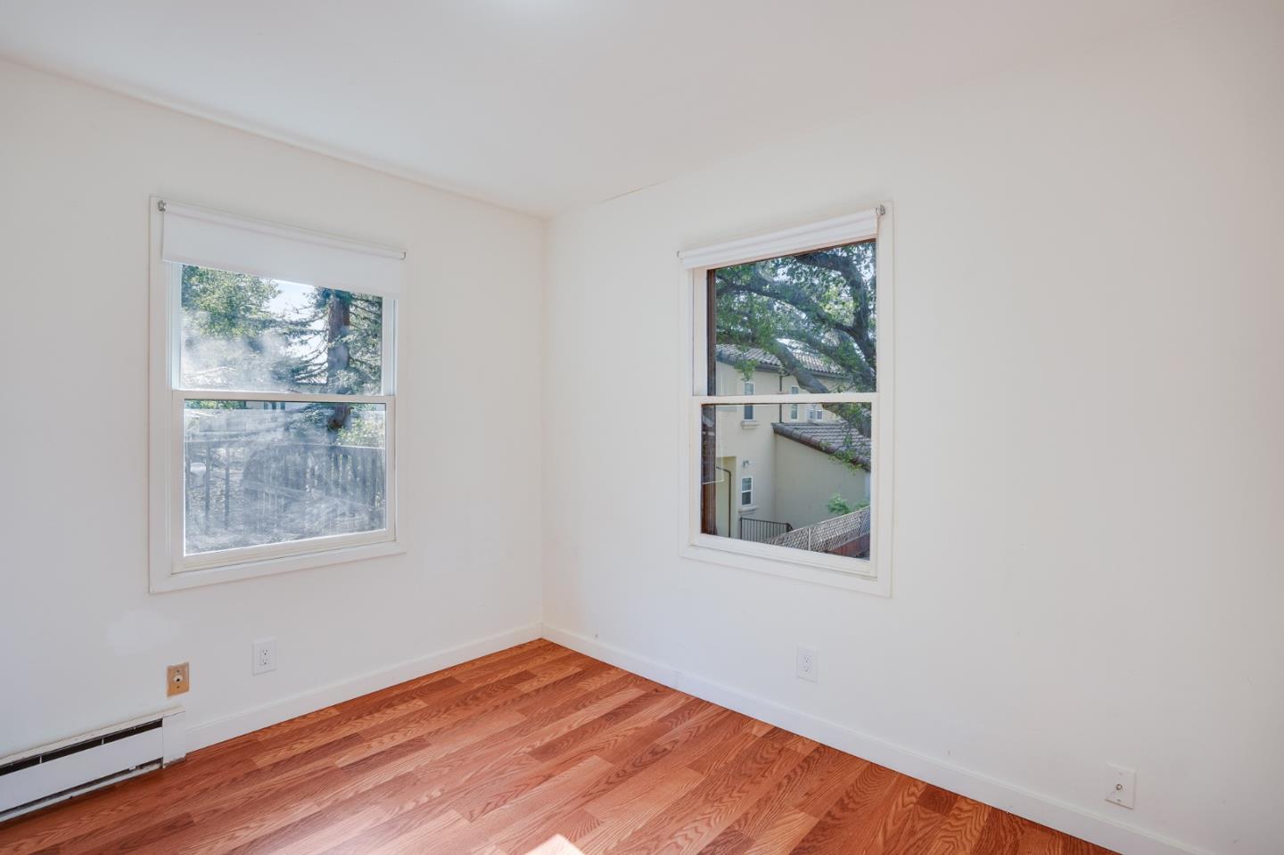 1218 Middlefield Road Palo Alto, CA 94301 - Photo 13 of 31 a view of an empty room with wooden floor and a window