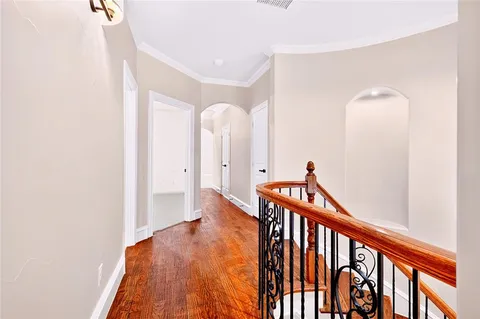 a view of a hallway with wooden floor and staircase