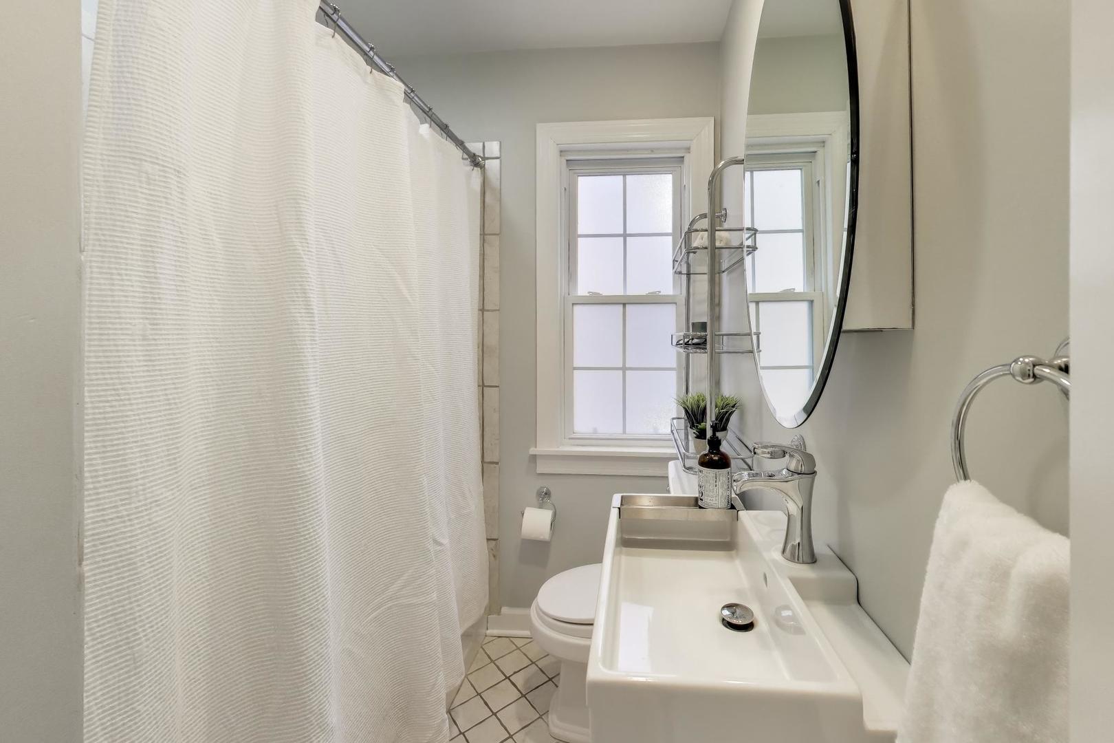 1103 Seward Street Evanston, IL 60202 - Photo 18 of 39 a bathroom with a sink a window and tub