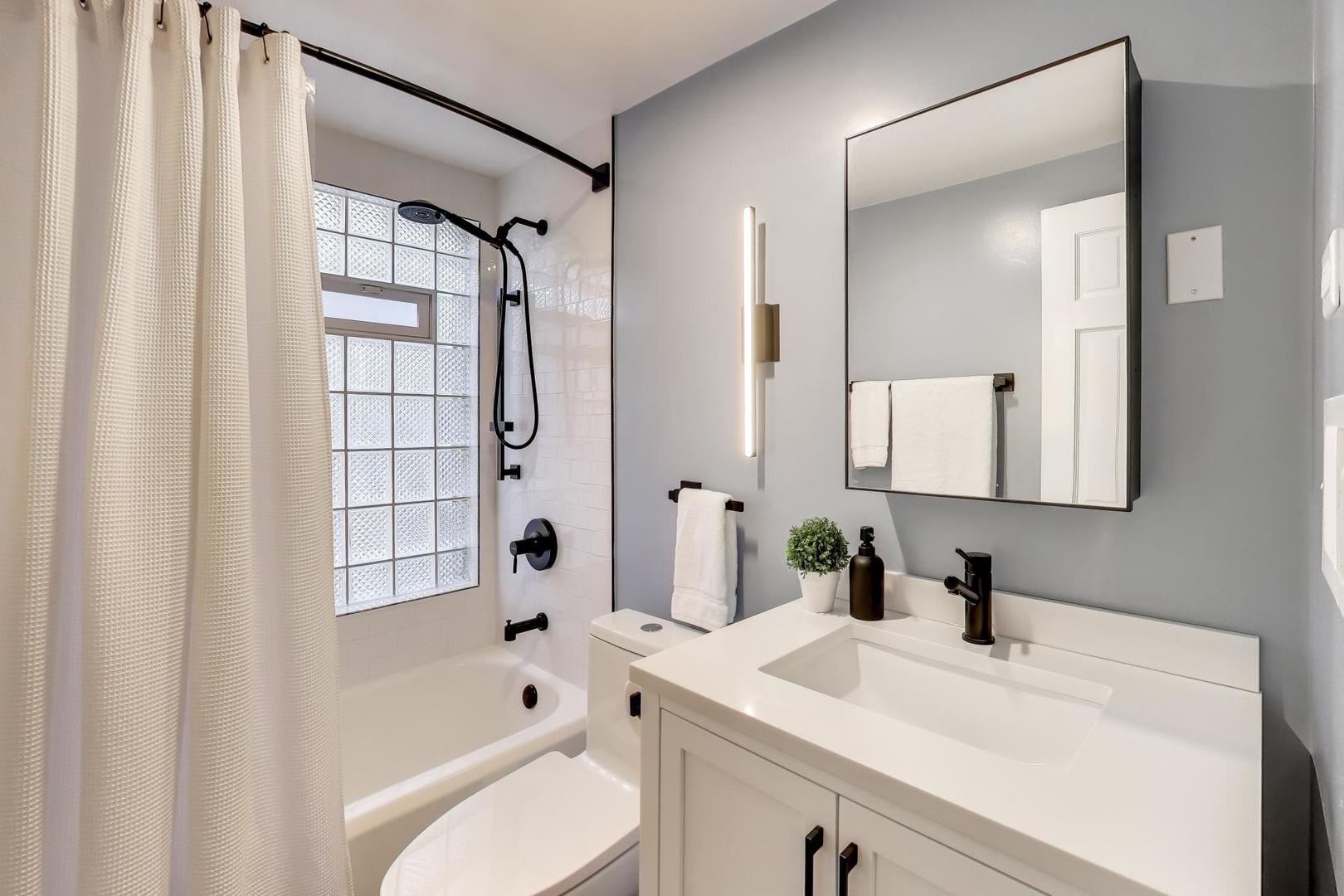 1103 Seward Street Evanston, IL 60202 - Photo 23 of 39 a bathroom with a sink vanity granite tub shower and a mirror