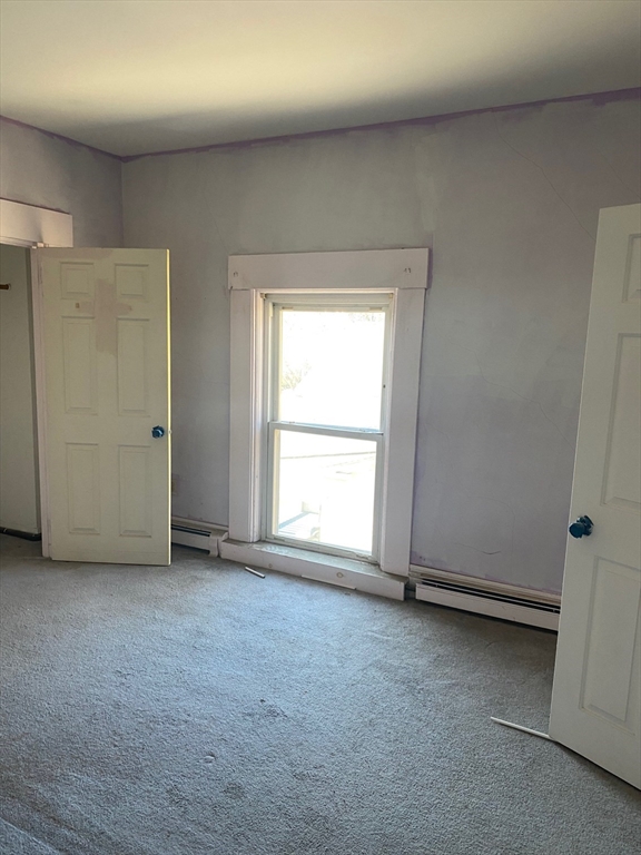 66 Main Street, Unit C Blackstone, MA 01504 - Photo 29 of 35 an empty room with a chair and a window