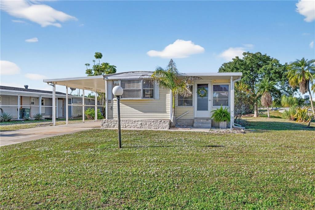 a view of a house with backyard and sitting area