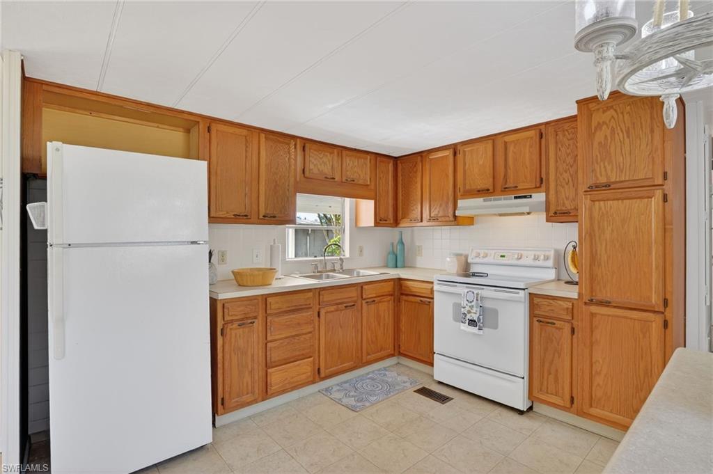 101 Rookery Road Naples, FL 34114 - Photo 11 of 43 a kitchen with a refrigerator sink and cabinets