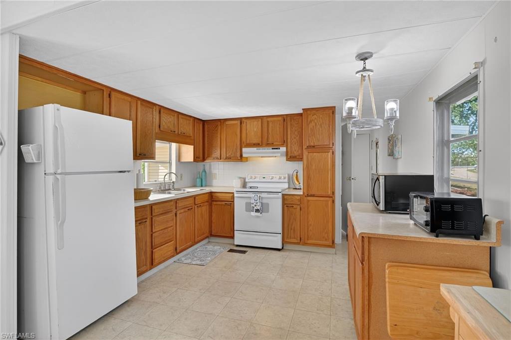 101 Rookery Road Naples, FL 34114 - Photo 10 of 43 a kitchen with a refrigerator a stove top oven a sink and cabinets