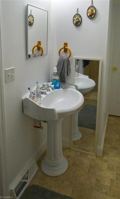 408 Hickory Chapel Road High Point, NC 27260 - Photo 20 of 23 Hall bath with new pedestal sink, vinyl floors, and tiled walk-in shower in 2017.