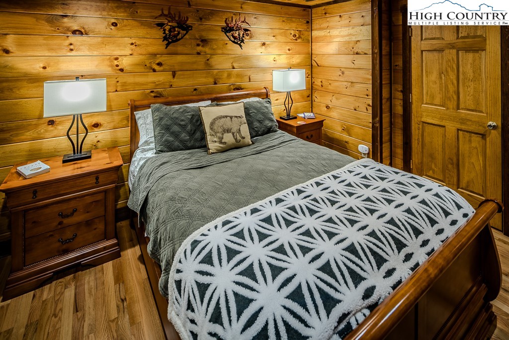 719 Pine Ridge Road Beech Mountain, NC 28604 - Photo 18 of 32 a bedroom with a bed and wooden floor