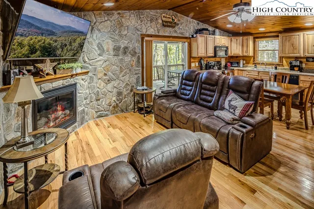 a living room with furniture a flat screen tv and a fireplace