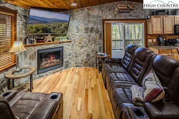 a living room with furniture a fireplace and a floor to ceiling window