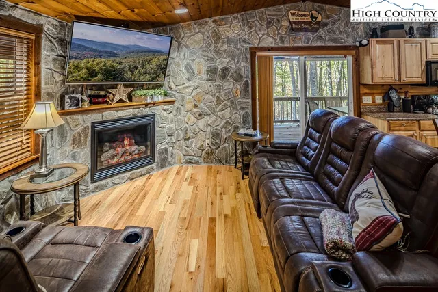 a living room with furniture a fireplace and a floor to ceiling window