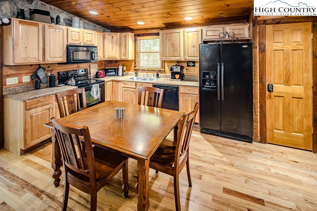 719 Pine Ridge Road Beech Mountain, NC 28604 - Photo 9 of 32 a kitchen with stainless steel appliances granite countertop a dining table chairs refrigerator and microwave
