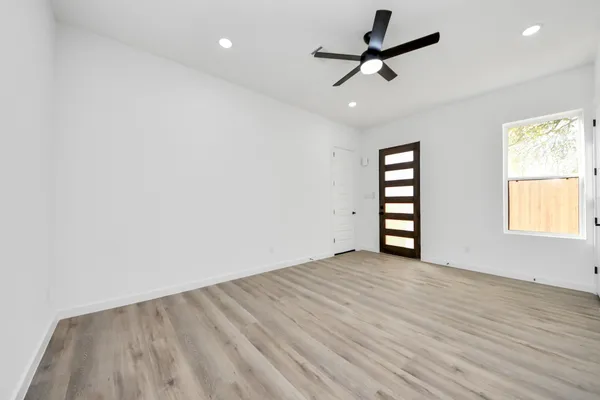 an empty room with windows and ceiling fan