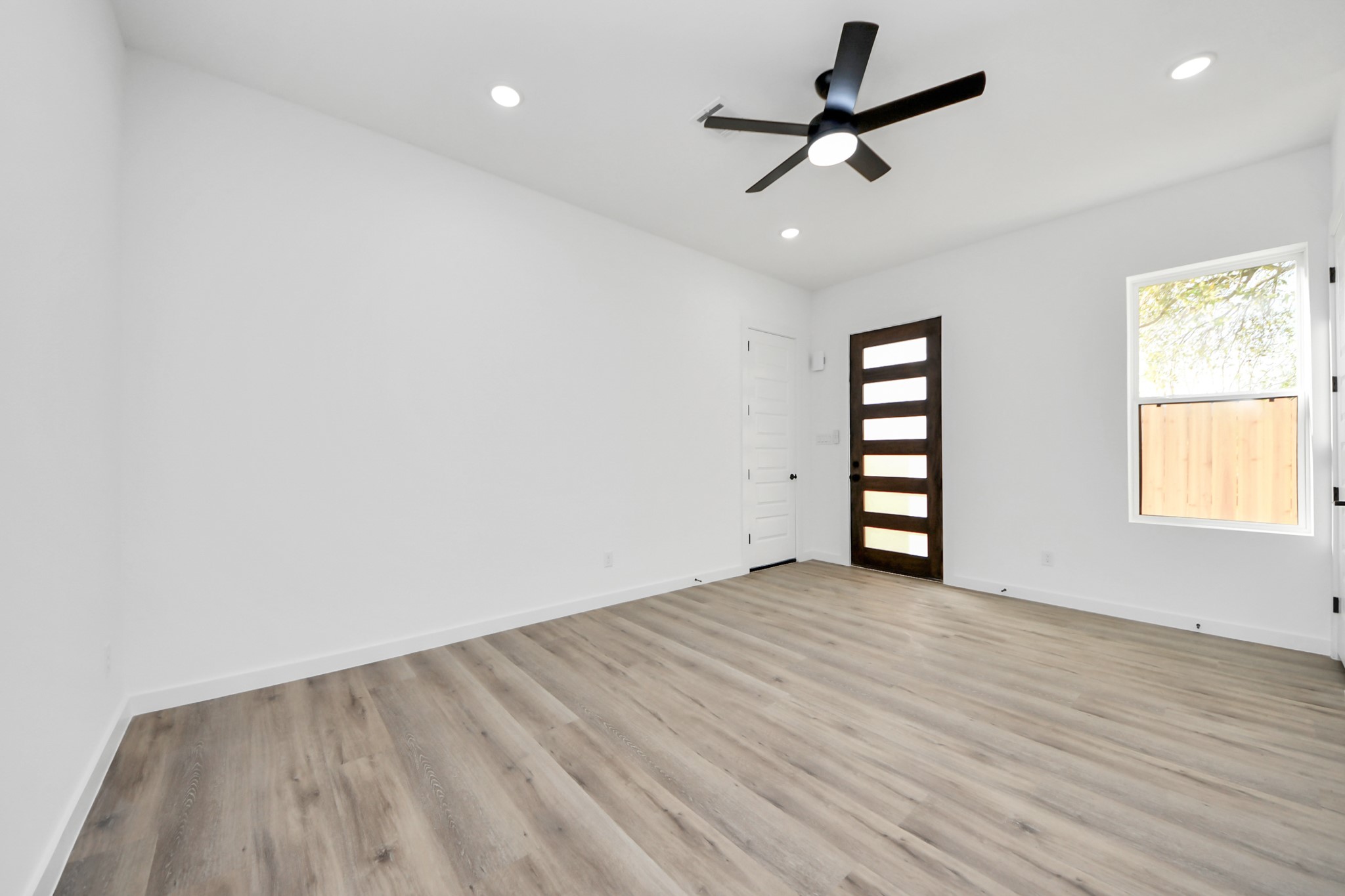 7935 Sunnyhill Street Houston, TX 77088 - Photo 3 of 21 an empty room with windows and ceiling fan