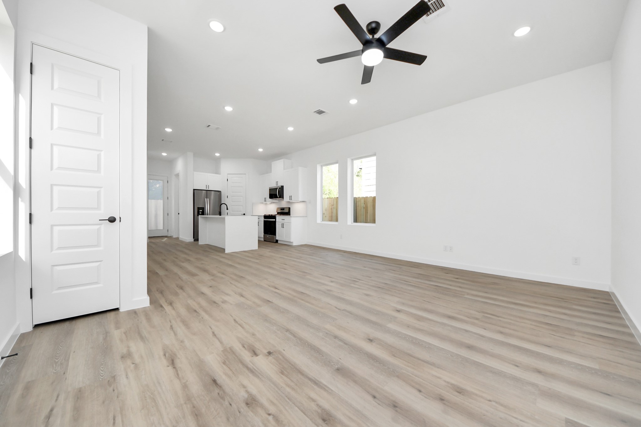 7935 Sunnyhill Street Houston, TX 77088 - Photo 4 of 21 an empty room with wooden floor cabinet and windows