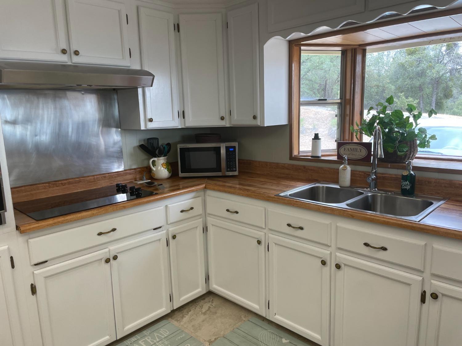 40640 Taylor Mountain Road Oakhurst, CA 93644 - Photo 20 of 62 a kitchen with granite countertop white cabinets and white appliances