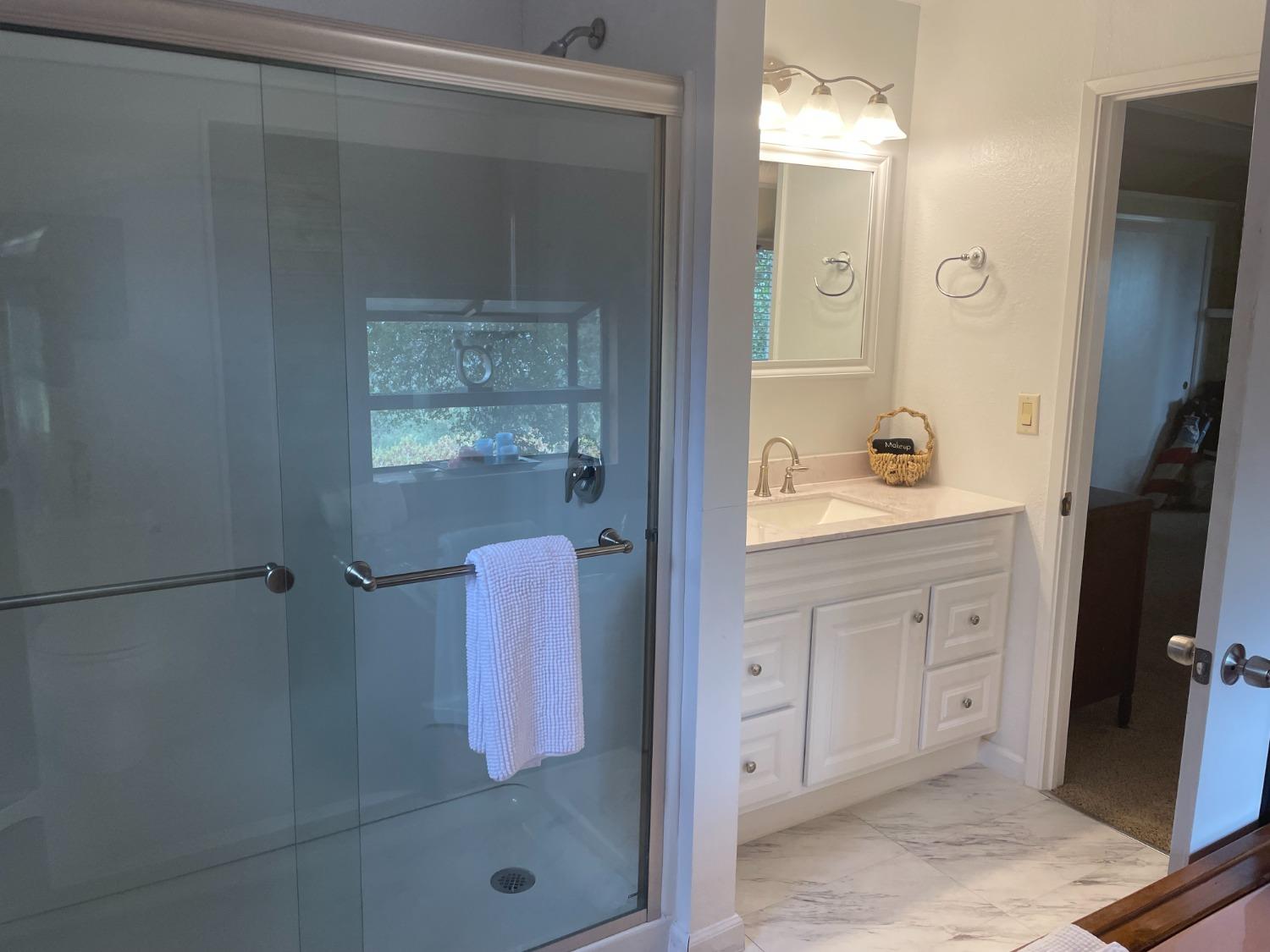 40640 Taylor Mountain Road Oakhurst, CA 93644 - Photo 40 of 62 a spacious bathroom with a shower sink and mirror