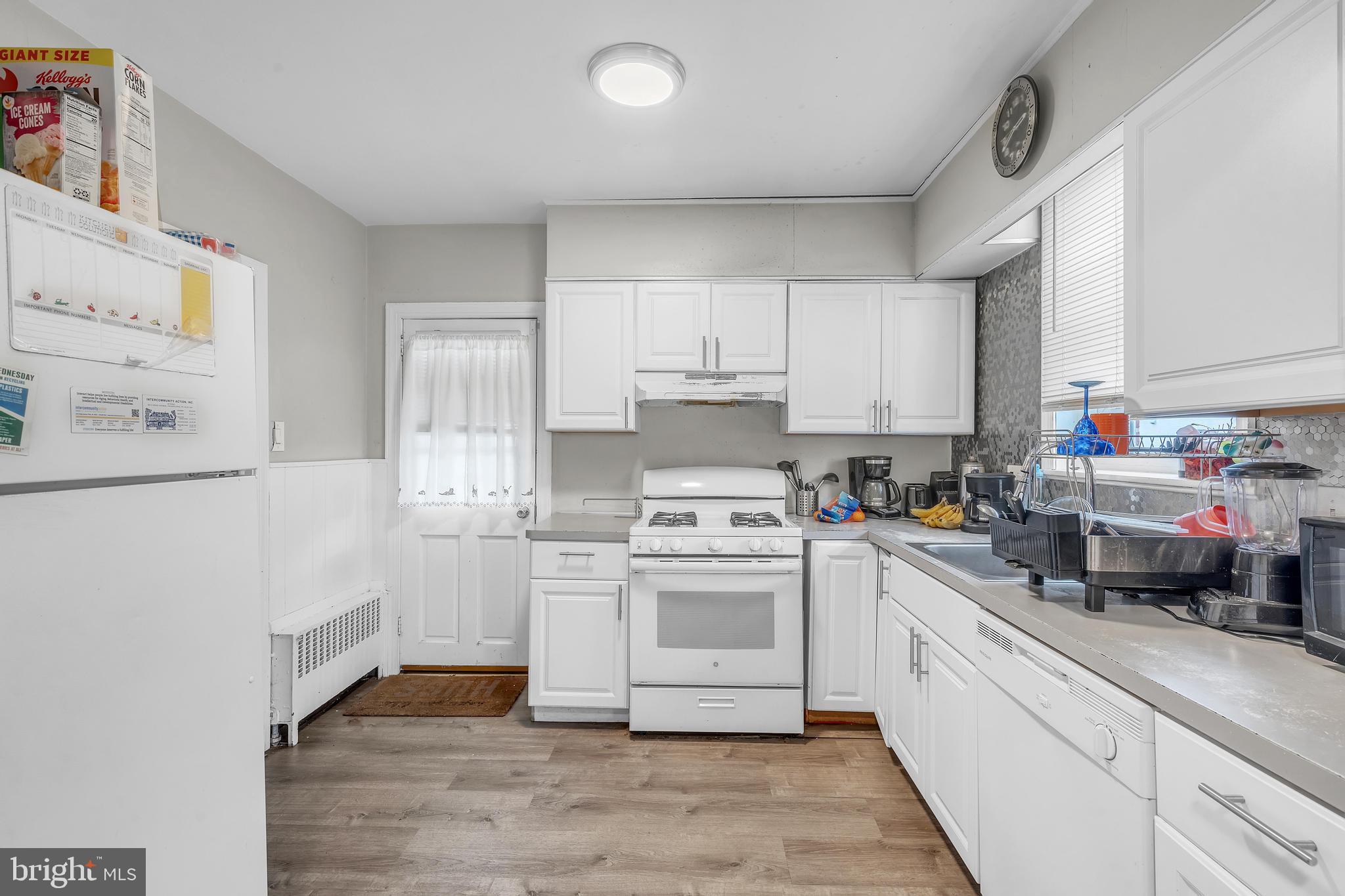 438 Holly Road Lansdowne, PA 19050 - Photo 7 of 17 a kitchen with a white cabinets and white appliances