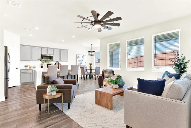 a living room with furniture kitchen view and a window
