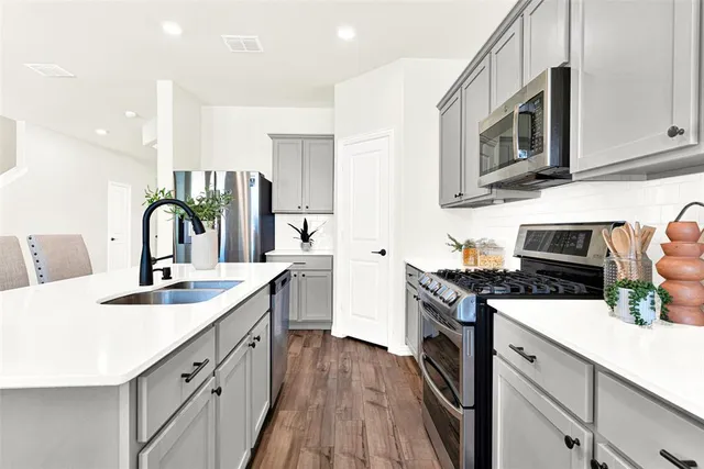 a kitchen with a sink stove and microwave