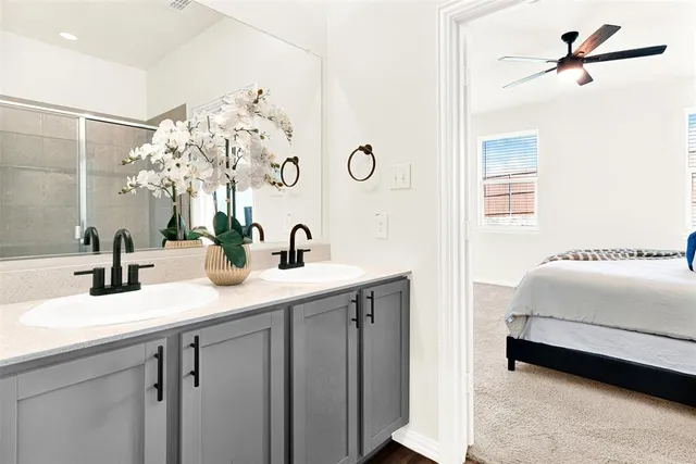 a en suite bathroom with a double vanity sink and a mirror
