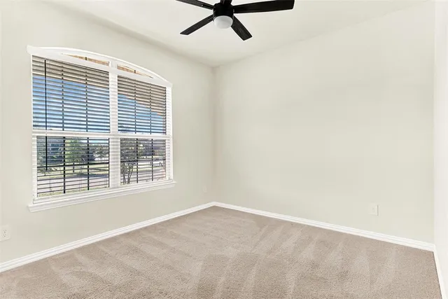 a view of a livingroom with a ceiling fan and window