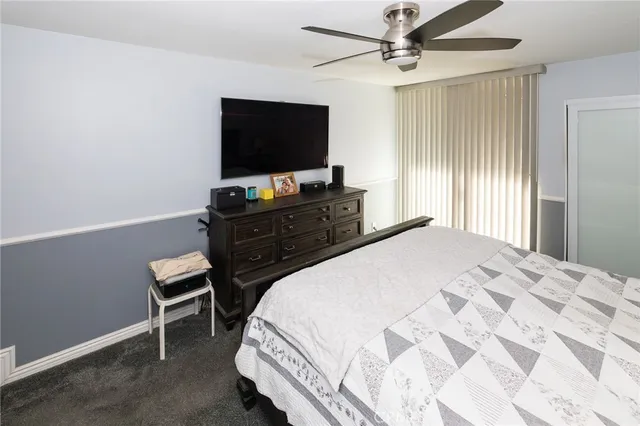 a bedroom with a bed and a flat tv screen on dresser