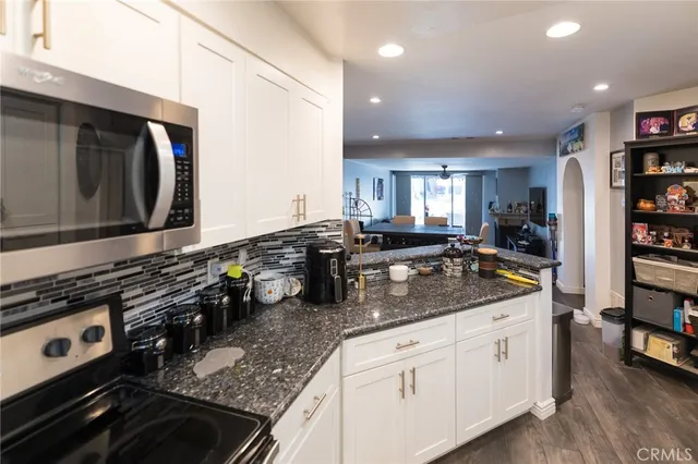 a kitchen with stainless steel appliances granite countertop a sink stove and cabinets