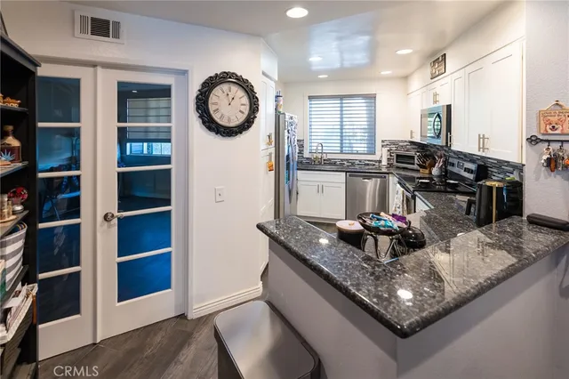 a kitchen with a stove a clock and cabinets