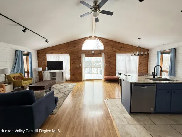 a large kitchen with stainless steel appliances granite countertop a sink dishwasher a dining table and chairs with wooden floor