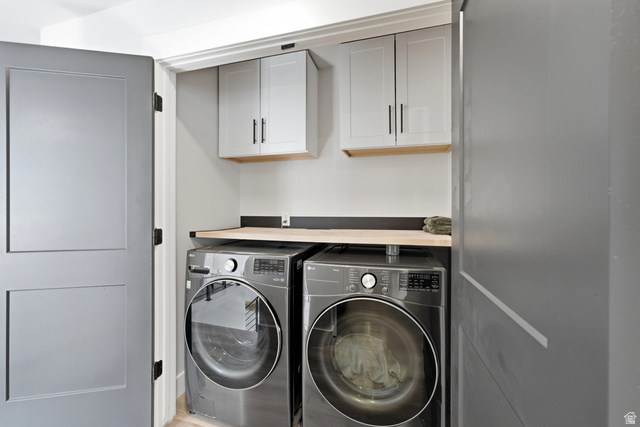 6039 North Westridge Road Heber City, UT 84032 - Photo 37 of 71 Dedicated laundry area featuring a light wood finish countertop, two upper cabinets with black hardware, and two front-loading machines