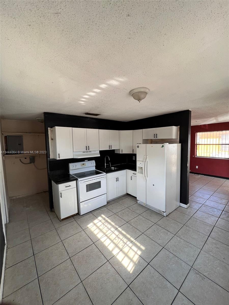 2315 Northwest 33rd Street, Unit 1 Miami, FL 33142 - Photo 7 of 7 a kitchen with cabinets and white appliances