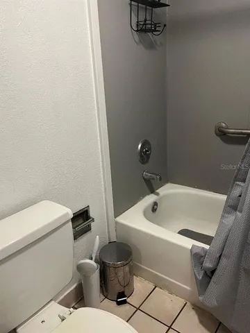a white toilet sitting next to a bath tub
