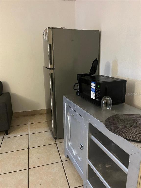 8421 South Orange Blossom Trail, Unit 303 Orlando, FL 32809 - Photo 10 of 15 a kitchen with a refrigerator and washing machine