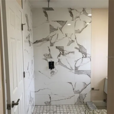 a bathroom with a granite countertop sink and a toilet