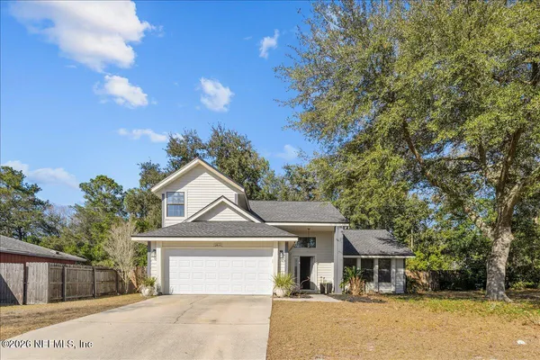 a front view of a house with a garden and tree