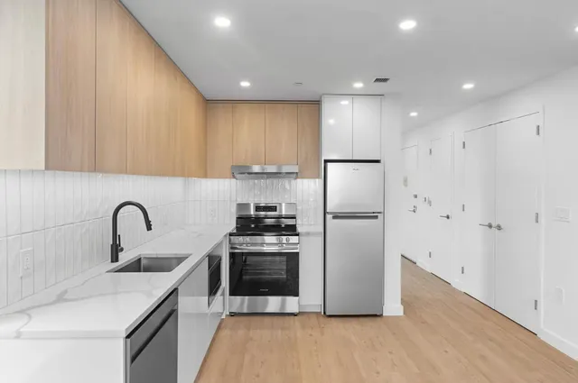 a kitchen with a refrigerator sink and cabinets