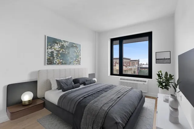 a bedroom with a bed and a large window